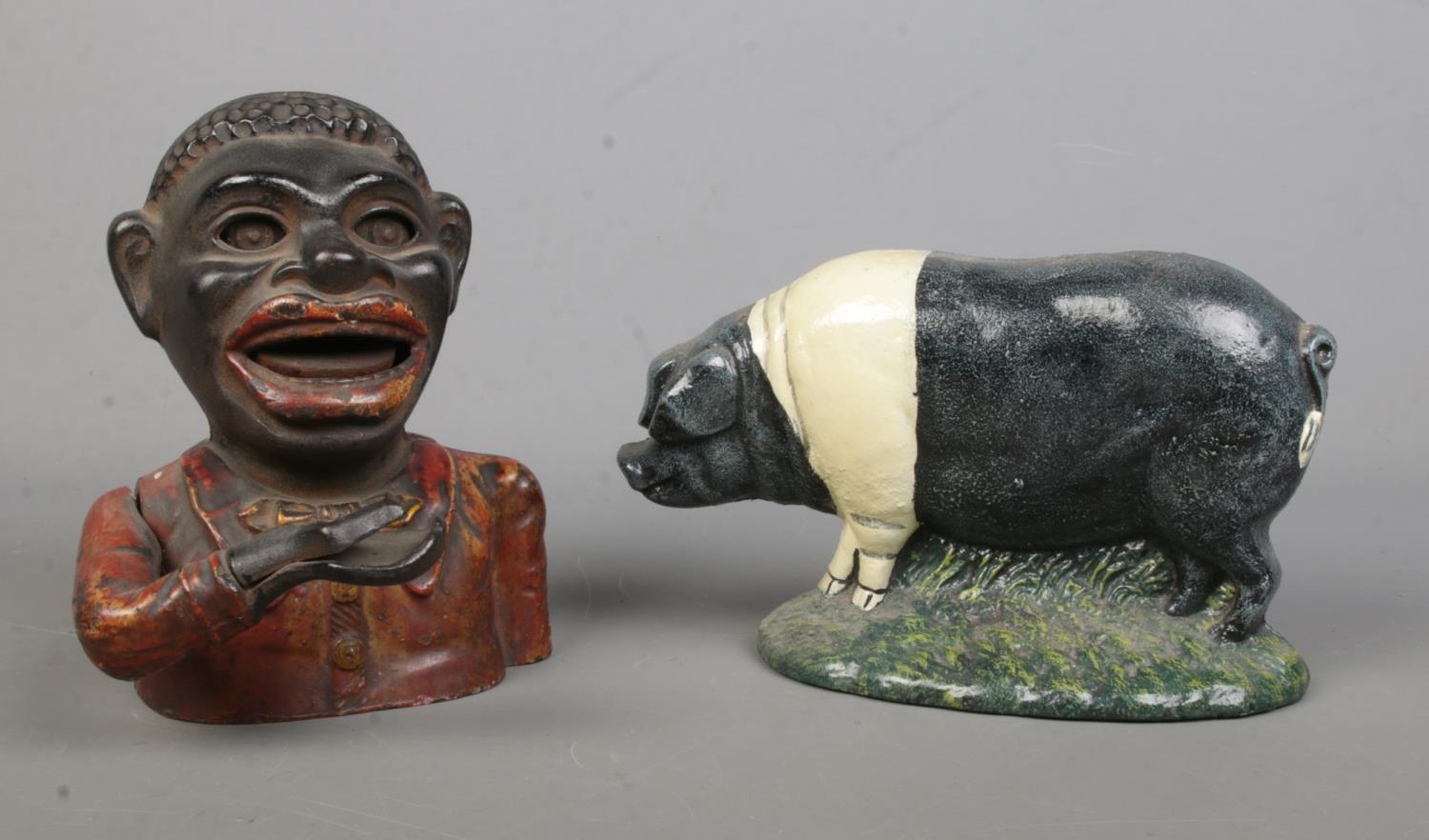 A cast alloy novelty money box, together with a door stop formed as a pig.