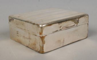 A George V silver mounted cigarette box, with banded top and H.M, 1929 to the top left corner.