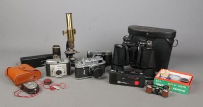A collection of photography and magnifying equipment, to include cased binoculars, brass bodied