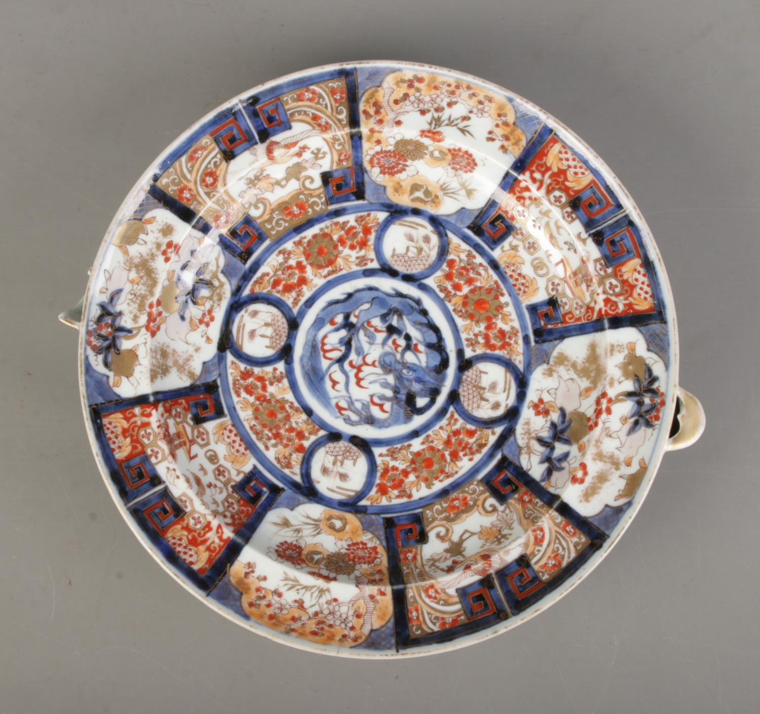 A Japanese Meiji period Imari plate warmer bearing central dragon motif and six character mark to