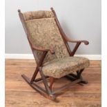 An Edwardian upholstered mahogany rocking chair.