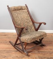 An Edwardian upholstered mahogany rocking chair.