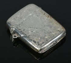 An Edwardian silver vesta case, bearing floral detailing and central heart crest. Assayed for