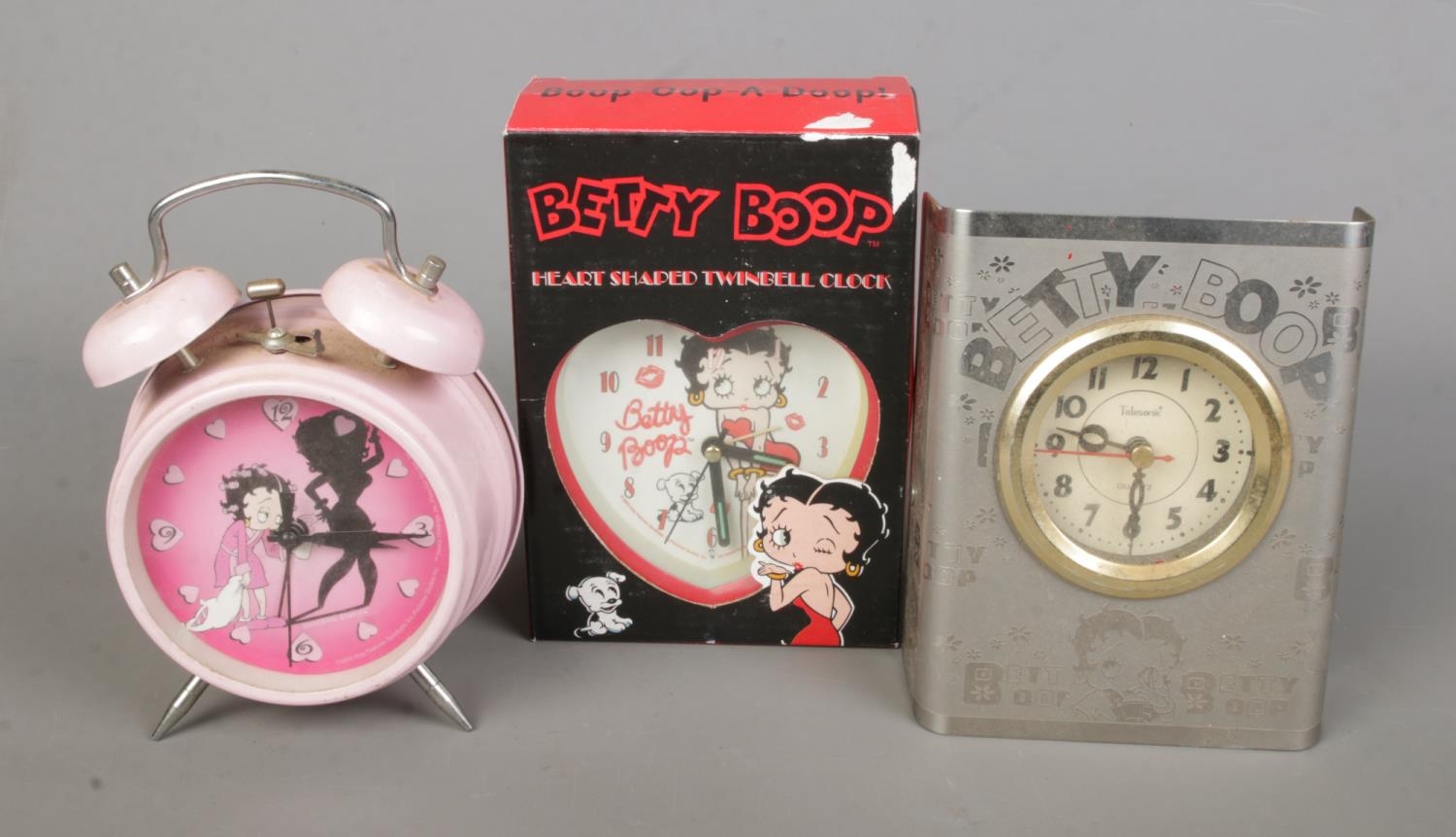 Three novelty Betty Boop clocks to include boxes heart shaped twinbell and quartz telesonic example.