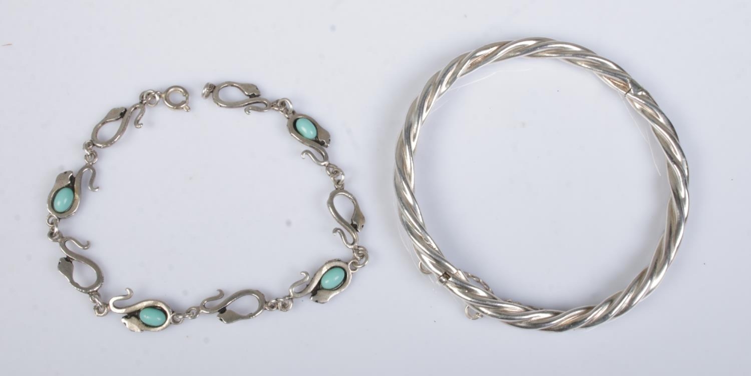 A silver and turquoise snake bracelet along with a silver bangle.