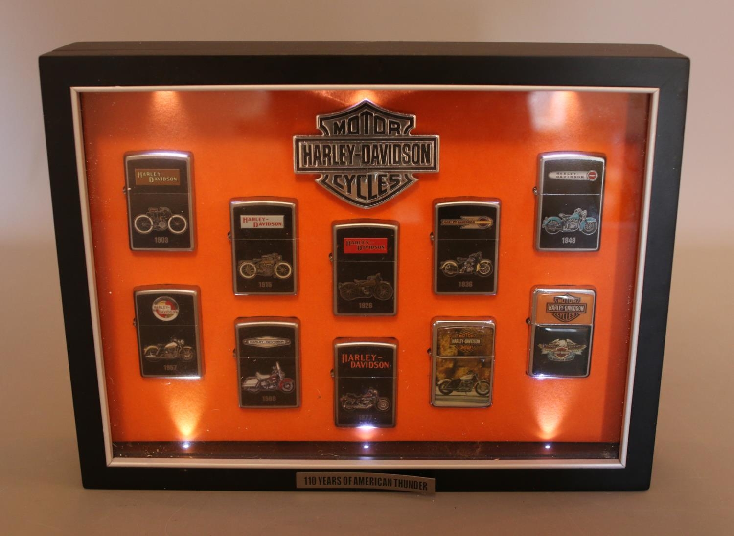 A Harley Davidson cased set of Zippo "100 Years Of American Thunder" lighters, containing 8/10