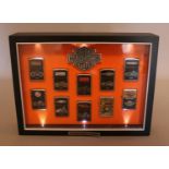 A Harley Davidson cased set of Zippo "100 Years Of American Thunder" lighters, containing 8/10