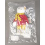 A Steiff Rupert Bear; 653551, in white, still in plastic packing bag. With yellow tag and button
