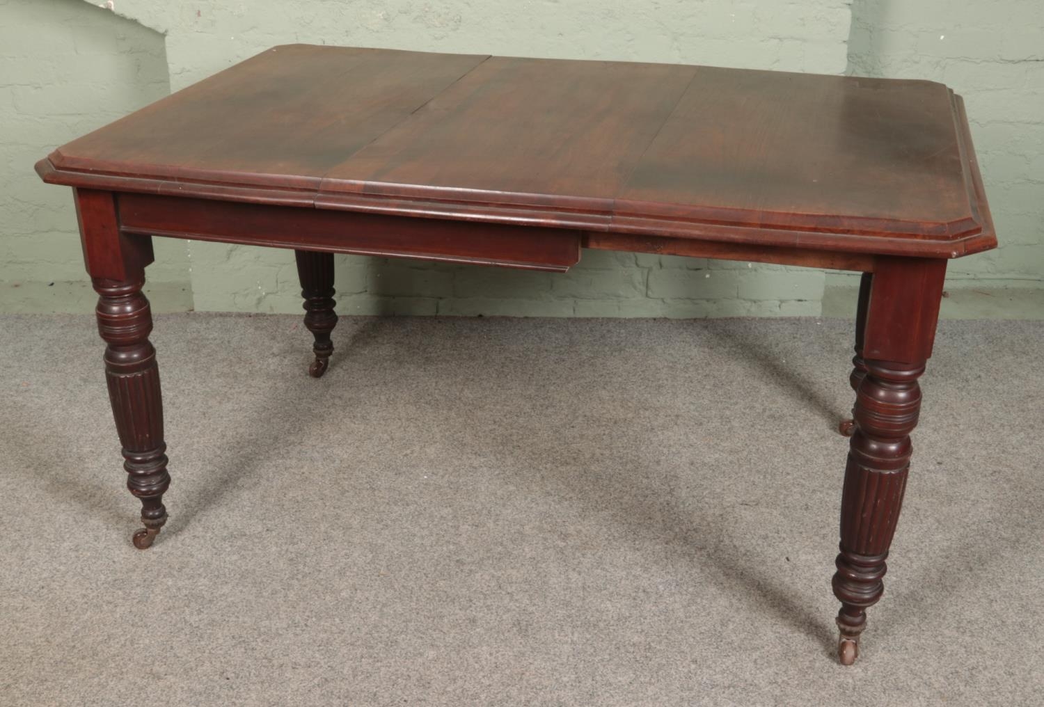 A mahogany extending dining table on turned reeded legs. Hx79cm Wx151cm Dx99cm Table does not come