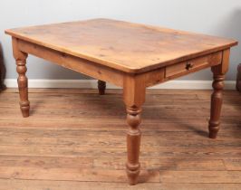 A large pine Farmhouse style table with drawers to both ends.