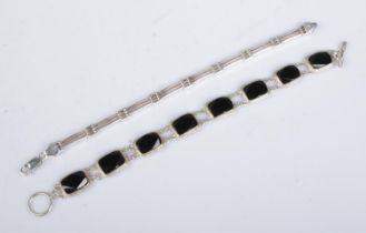 Two silver bracelets. One set with black coloured panels.
