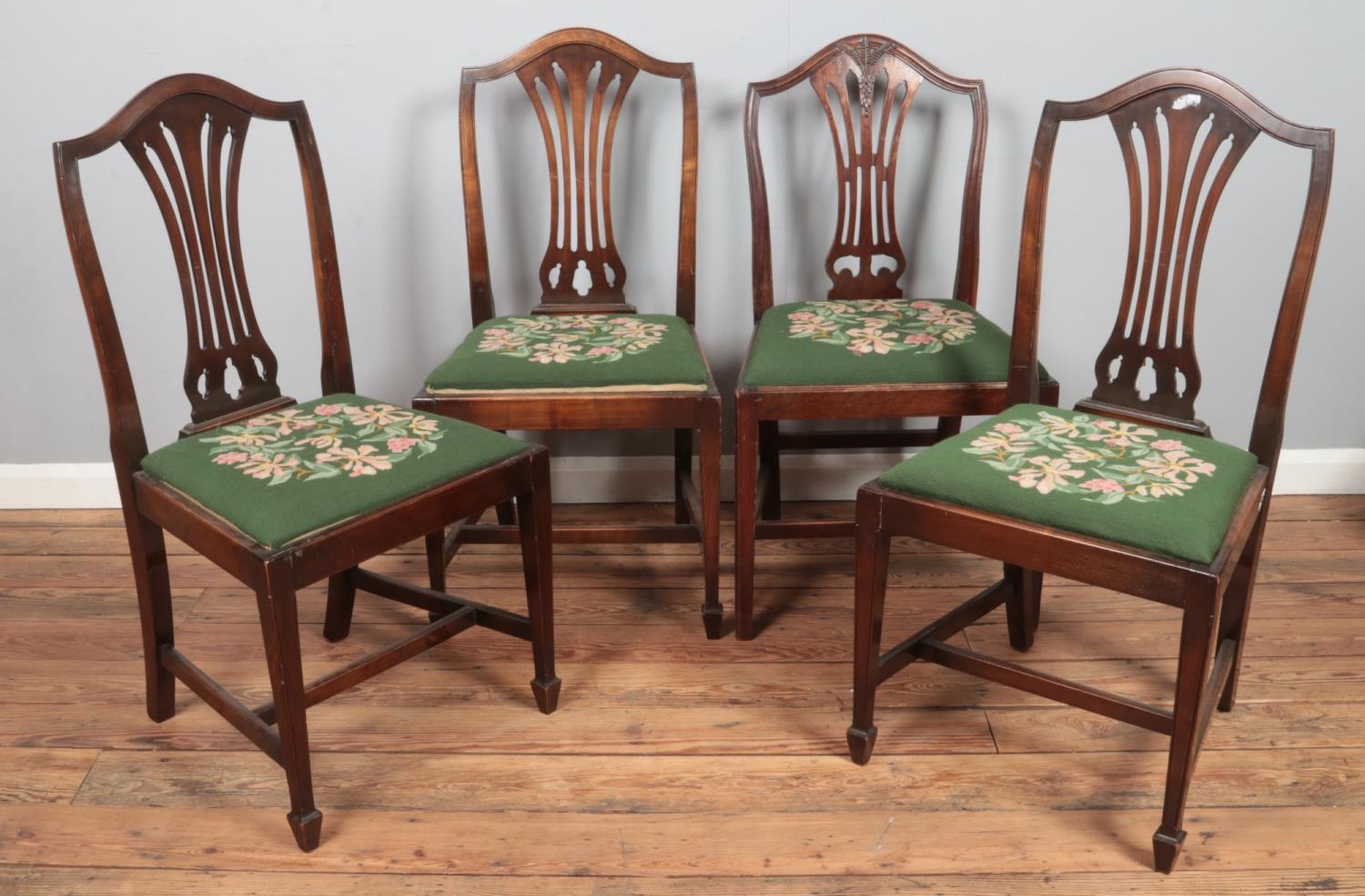 A matched set of four mahogany dining chairs. Three with pierced slats, the other similar having