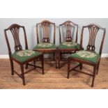 A matched set of four mahogany dining chairs. Three with pierced slats, the other similar having