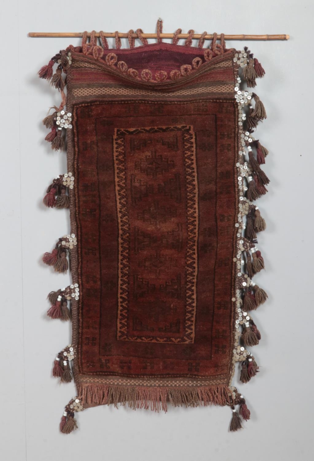 An antique Eastern saddle bag rug, with frilled and tasseled edge. Length: 112cm, Width: 55cm