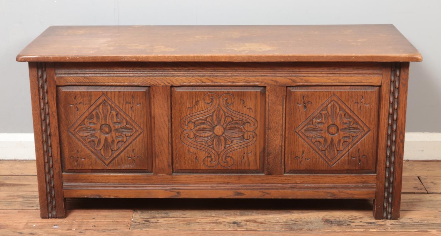 An Old Charm style paneled blanket box/coffer, with carved detailing. Height: 51cm, Width: 112cm,