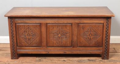 An Old Charm style paneled blanket box/coffer, with carved detailing. Height: 51cm, Width: 112cm,