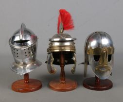 A collection of three Sutton Hoo miniature helmets
