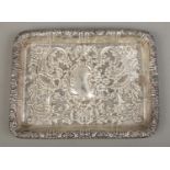 A rectangular silver tray, with repousse decoration and blank kidney shaped crest. Assayed for