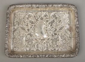 A rectangular silver tray, with repousse decoration and blank kidney shaped crest. Assayed for