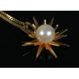 An 18ct Gold starburst shape pendant, set with central pearl, suspended on an 18ct Gold chain. Total