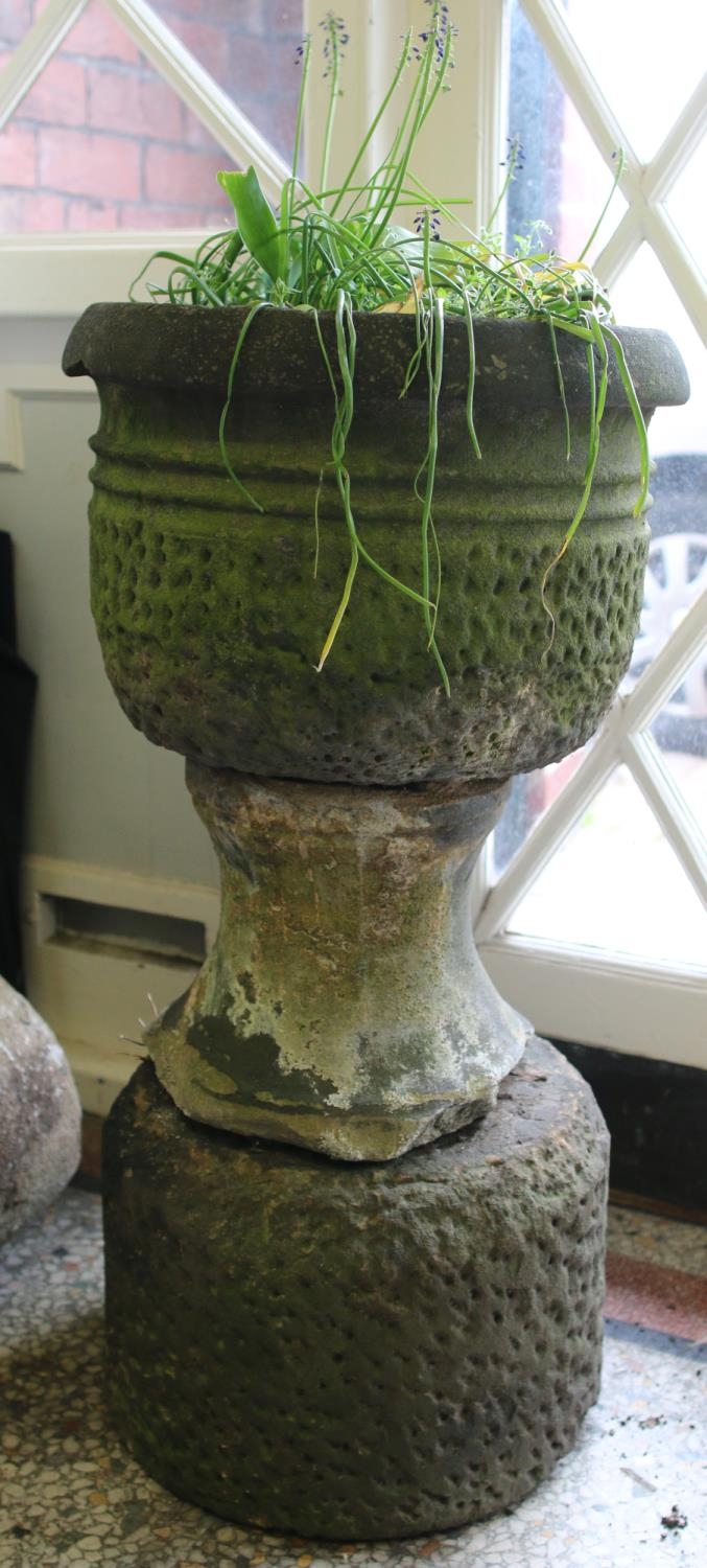 A carved stone garden urn on base.