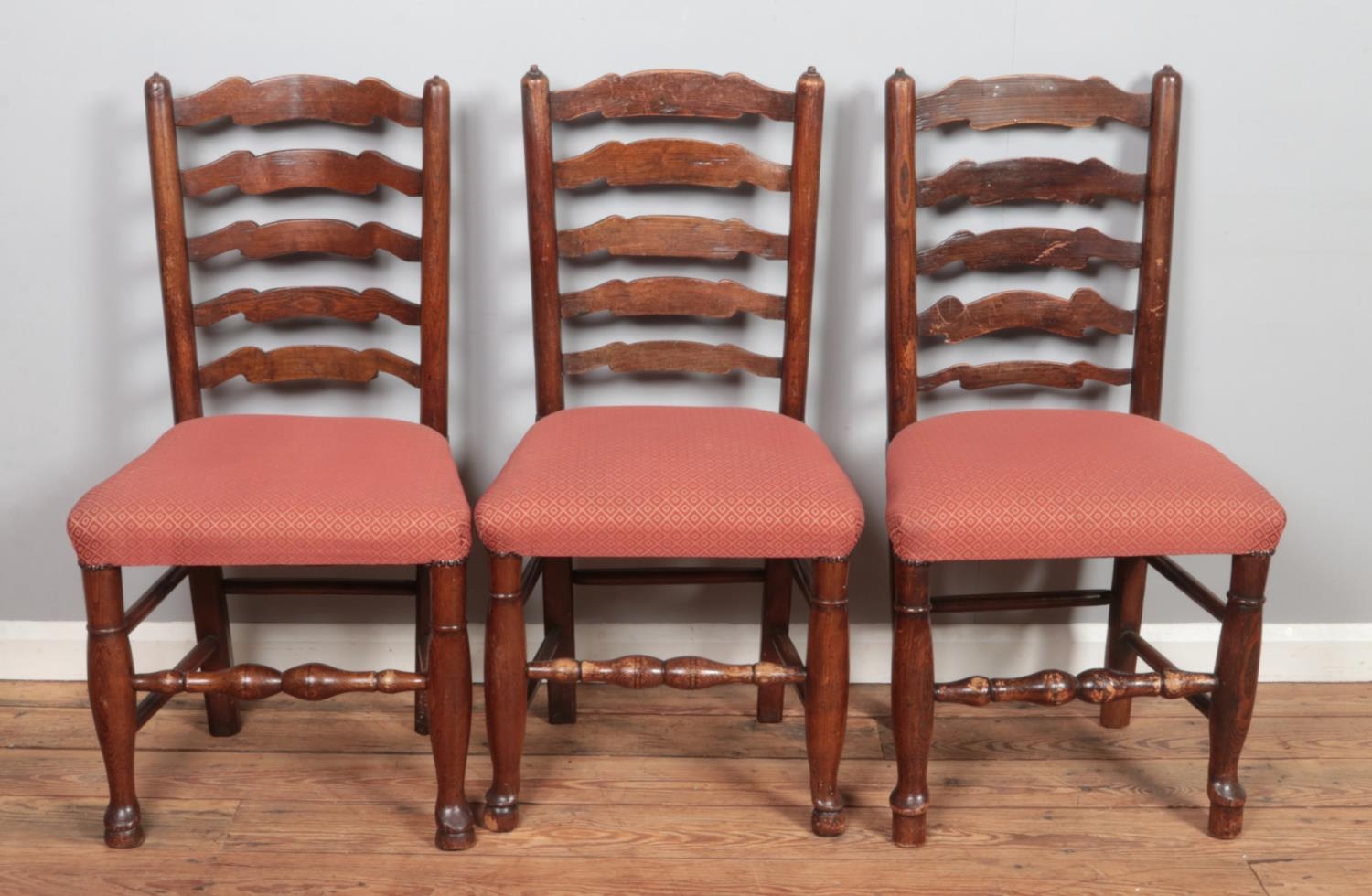 A set of four ladder back dining chairs along with two similar carver examples.