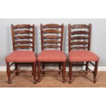 A set of four ladder back dining chairs along with two similar carver examples.