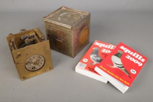 A rare antique pigeon clock "The Settle Clock" in tin travel case, stamped "25929-04 442" with two