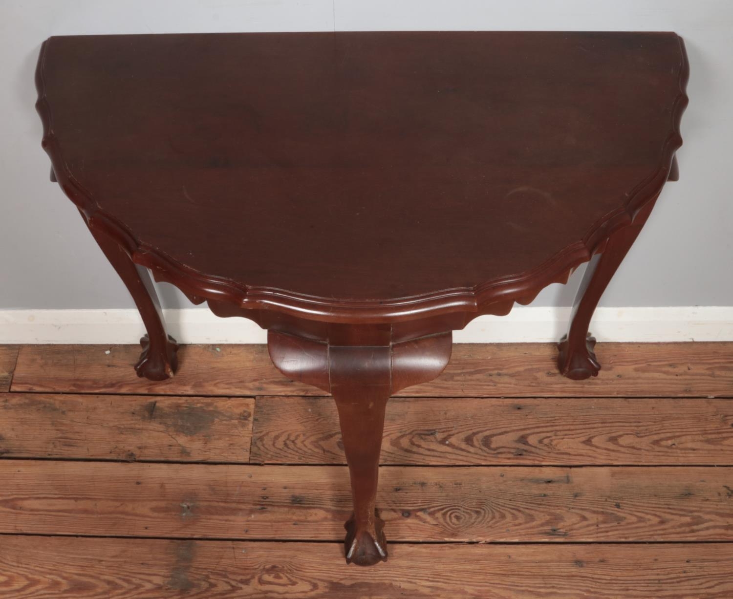 A mahogany demi-lune console table, with waved edging and three ball and claw feet. Bearing label - Image 2 of 3
