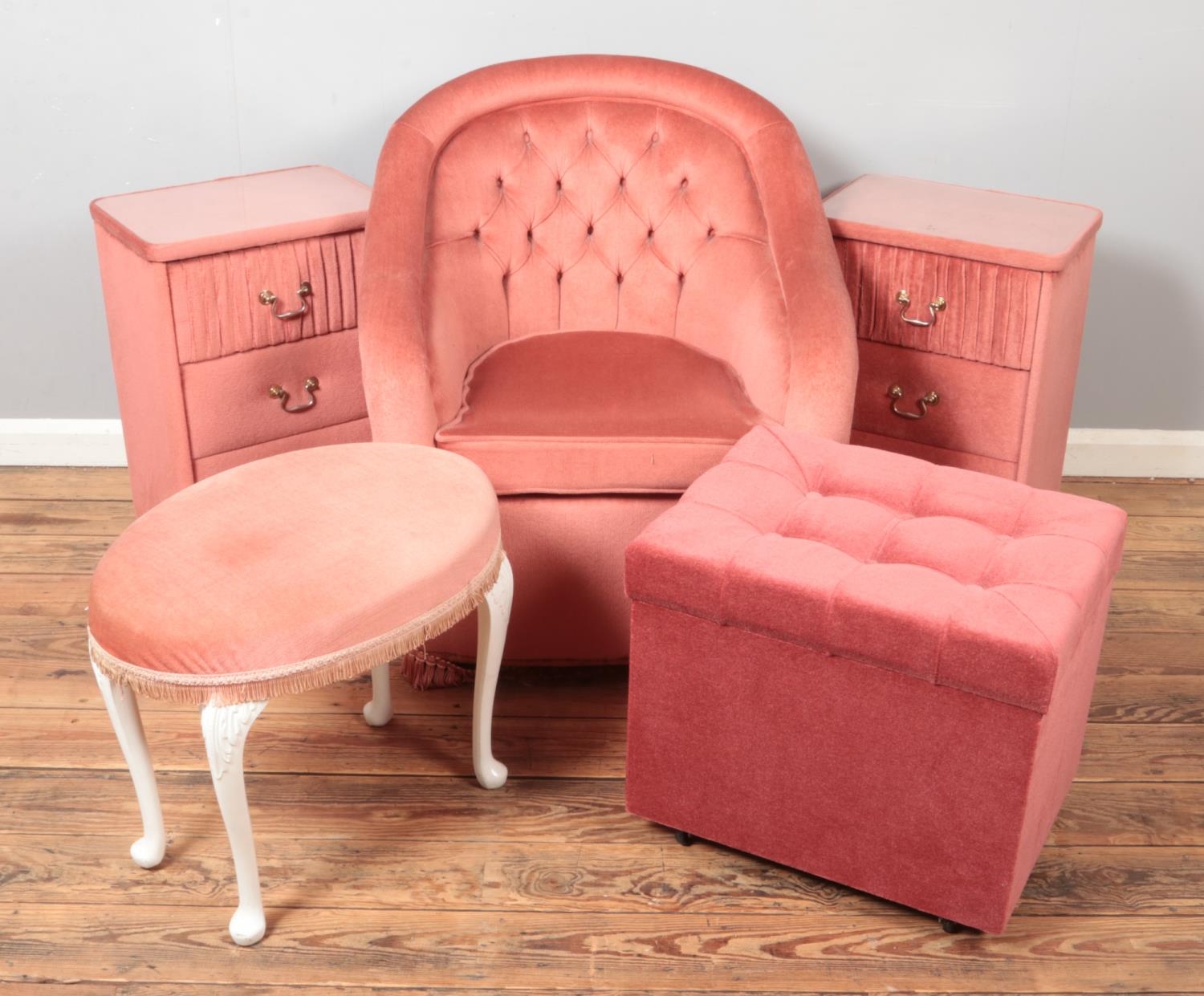 Five pieces of pink upholstered furniture. Includes pair of bedside chests, arm chair, storage box