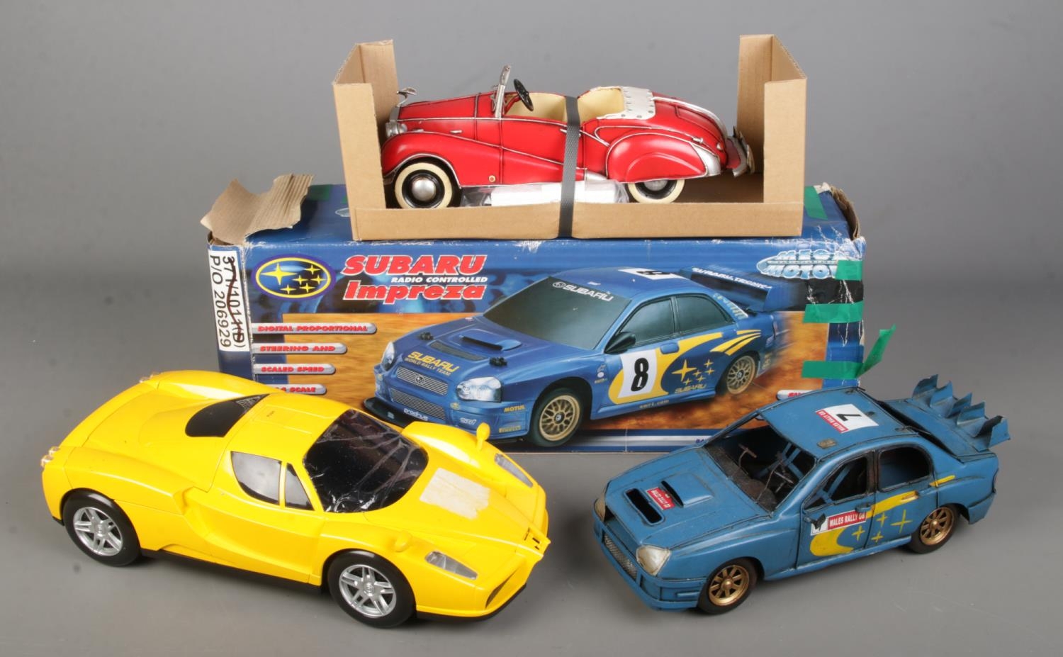 A collection of vintage cars including a Ferrari shaped cd player, remote control Subaru Impreza and