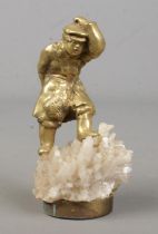 A brass figure of a man raised on crystal base. Marked 3K 1864 to back of leg. 10cm.