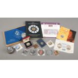 A collection of commemorative coins including The Heraldry of the Coronation Coin Set, King George