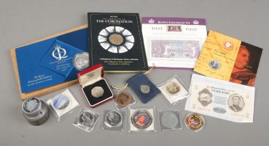 A collection of commemorative coins including The Heraldry of the Coronation Coin Set, King George