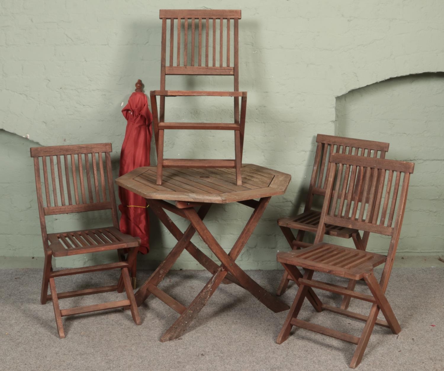 A six piece hardwood garden furniture set. Contains folding table, four chairs and parasol. Some