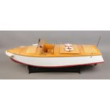 A motorised pond cruiser titled Sea Breeze on display stand. Approx. boat length 60cm.