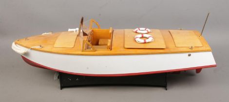 A motorised pond cruiser titled Sea Breeze on display stand. Approx. boat length 60cm.