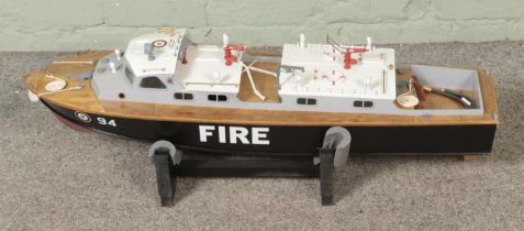 A remote control kit built model fire rescue boat, number 94, on display stand. Includes