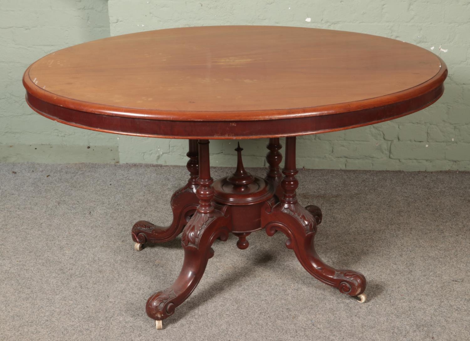 A mahogany breakfast table with oval top and carved base