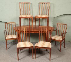 A Mcintosh teak extending dining table with six chairs including two carvers. Table not extended