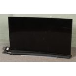 A 55 inch Samsung Curve smart TV with sound bar and subwoofer, comes with remotes and cables.