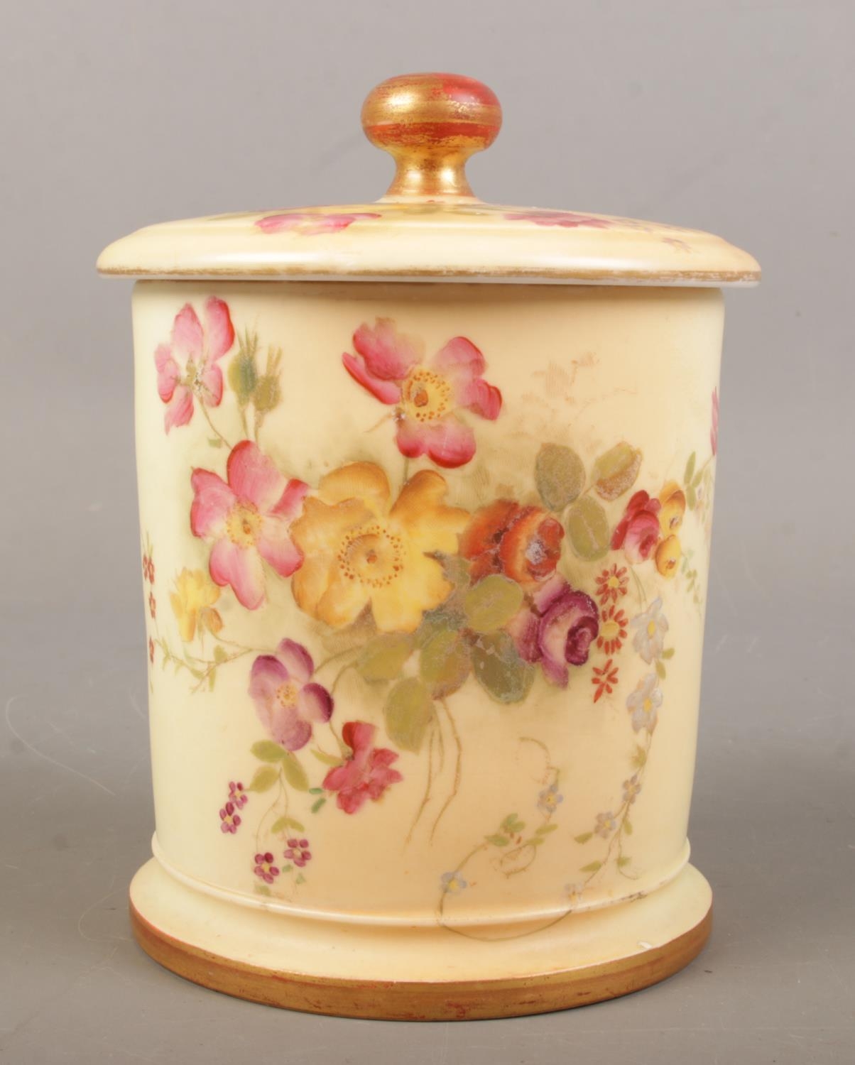 A Royal Worcester blush ivory lidded pot with hand painted floral decoration. Date mark for 1896.