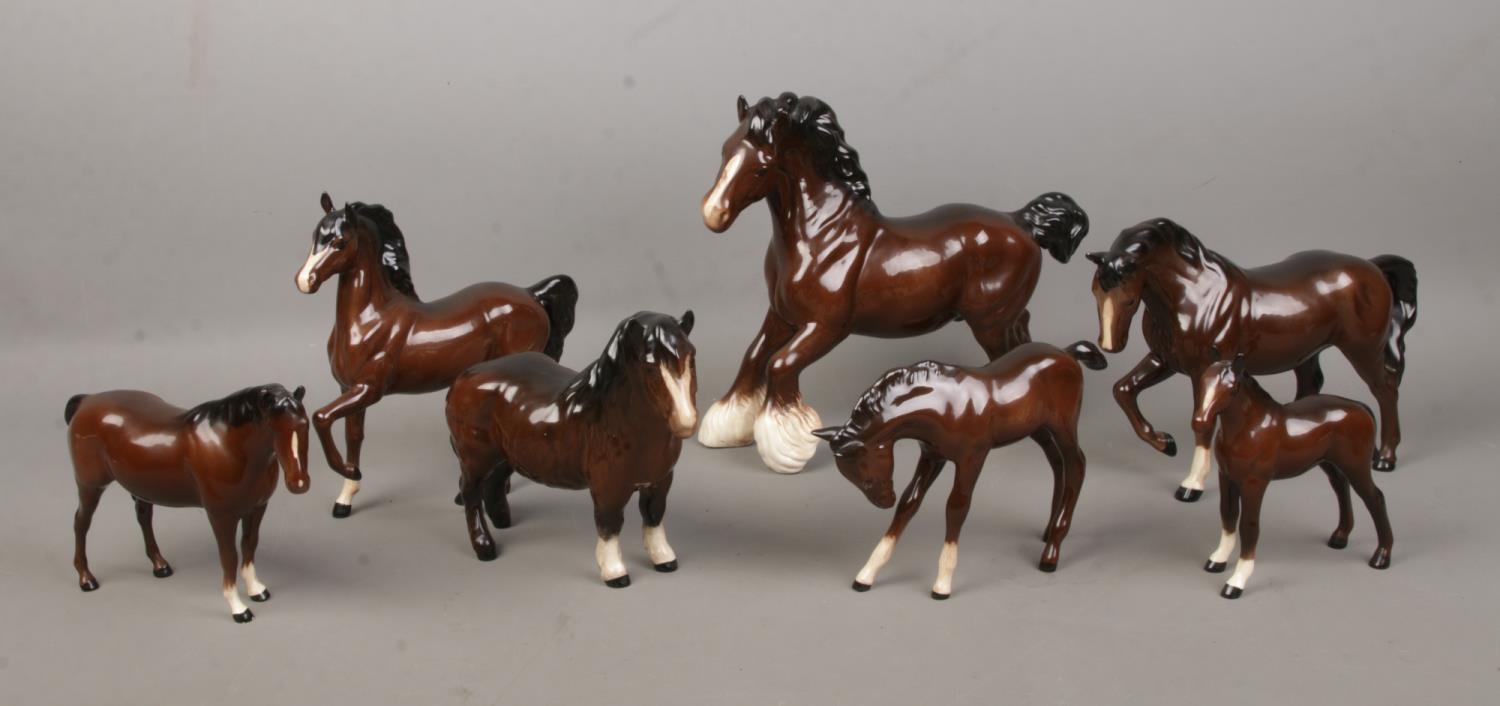Seven Royal Doulton ceramic horses, to include Shire Horse and foal examples. Back leg has been re-