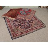 A collection three of rugs including red and blue floral design with central medallion.