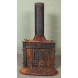 A large cast iron stove, with twin doors to the front. Stamped 'Made in West Germany' to the back.