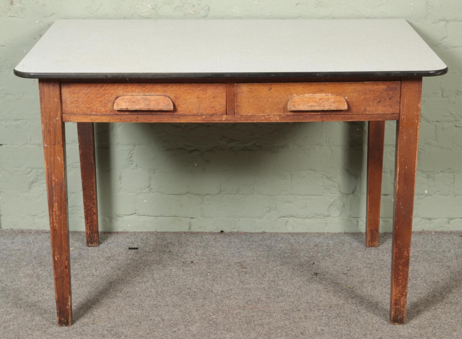 A 1930's oak desk with two drawers under a Formica top. Hx77cm Wx144cm Dx75cm