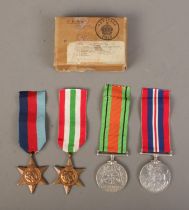 A set of four WWII medals with ribbons in original post box, name unknown. Includes War Medal,