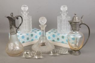 A collection of decanters and claret jugs. Includes two boxed Bohemia examples, four glass stoppers,