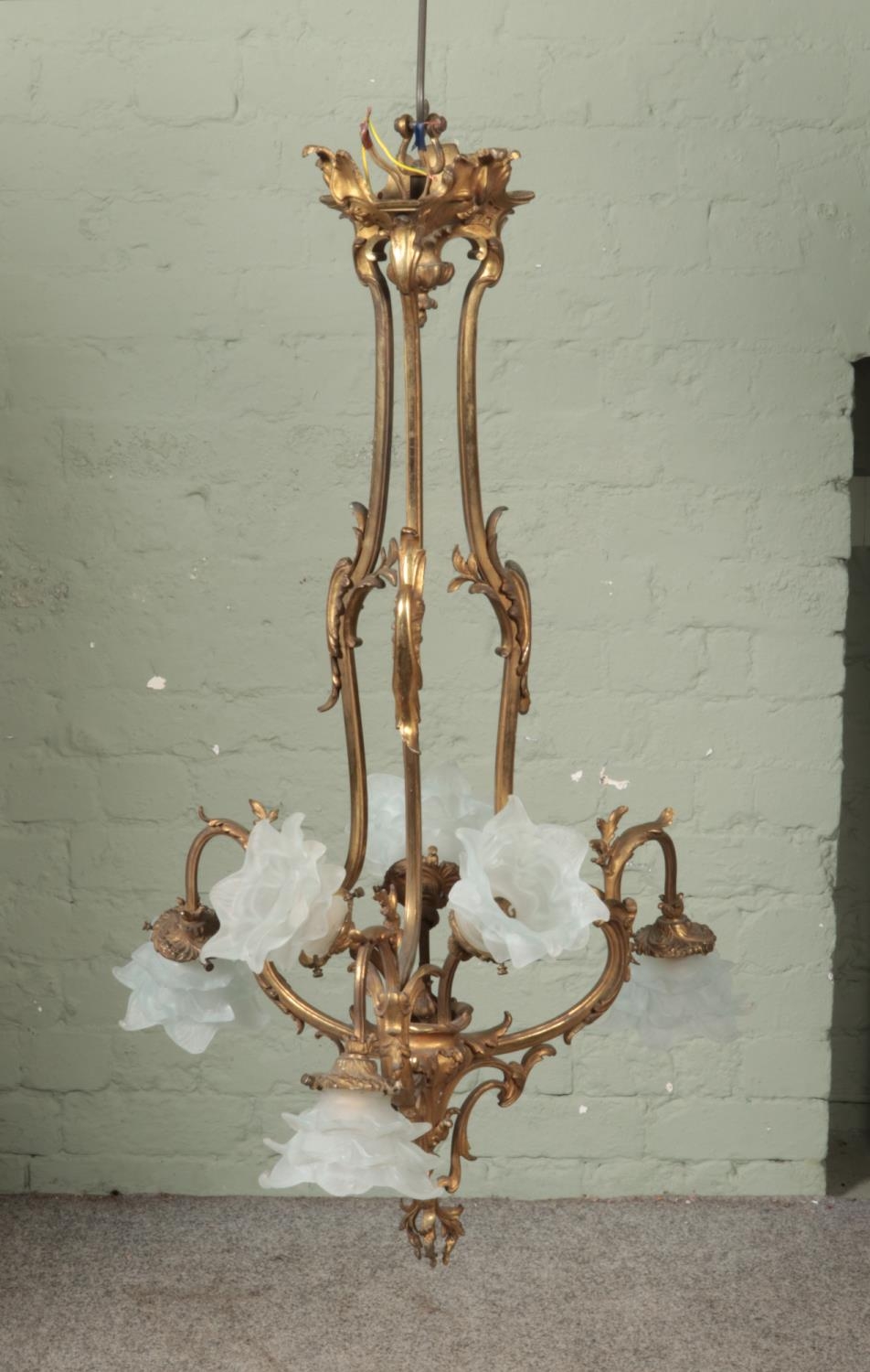 A large six branch gilt chandelier featuring floral frosted glass shades. Approx. height 92cm.