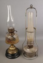 A Victorian brass and glass oil lamp together with a hanging railway oil lamp produced by Aladdin.